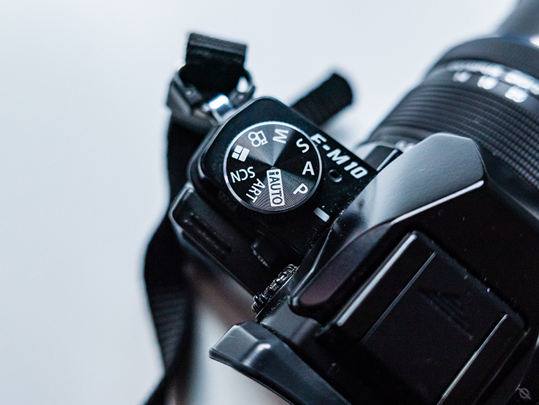 Close-up of a camera mode dial showing various shooting modes, including Auto, P, S, A, M, and scene selections.